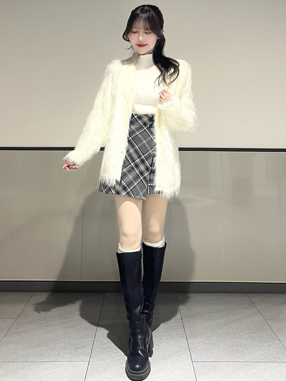 ホワイト系のカーディガン/ボレロ、ホワイト系のニット/セーター、グレー系のスカートを着用したレディースの秋コーディネートの2枚目の写真