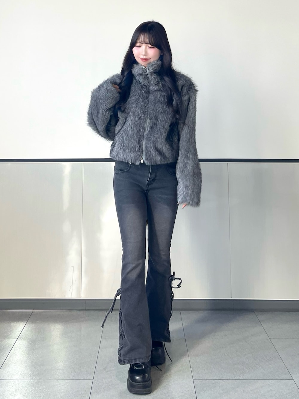 グレー系のブルゾン、グレー系のデニムパンツを着用したレディースの秋コーディネートの2枚目の写真