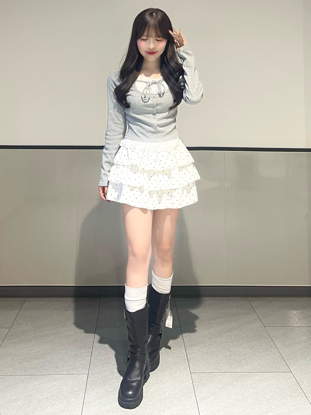 グレー系のTシャツ/カットソー、ホワイト系のスカート、ブラック系のブーツを着用したレディースの春コーディネートの2枚目の写真