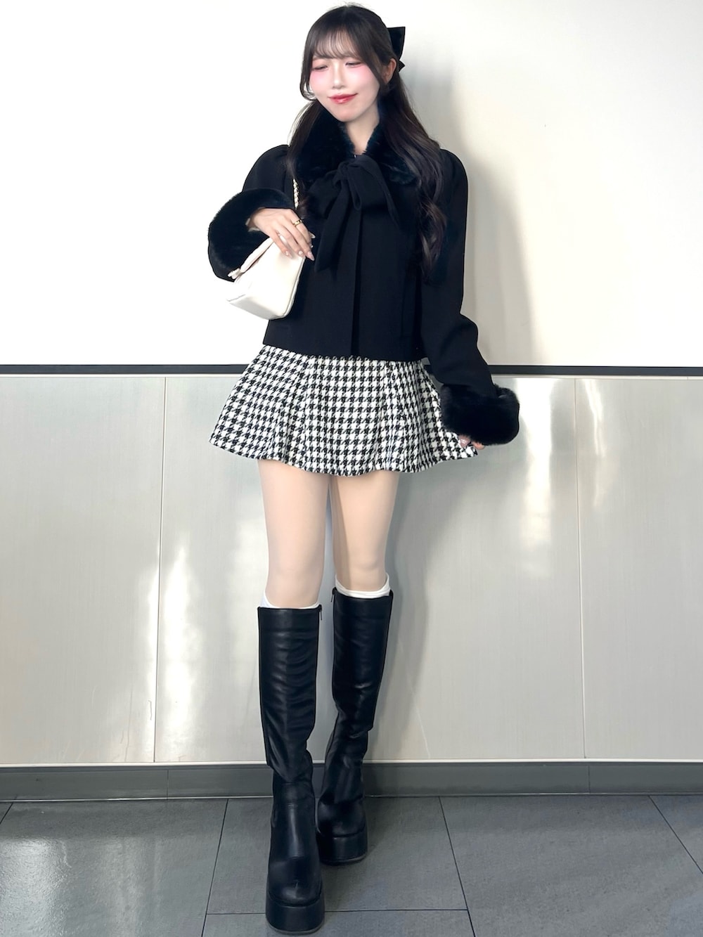 ブラック系のダウンジャケット/コート、ホワイト系のショルダーバッグ、その他のスカートを着用したレディースの冬コーディネートの2枚目の写真