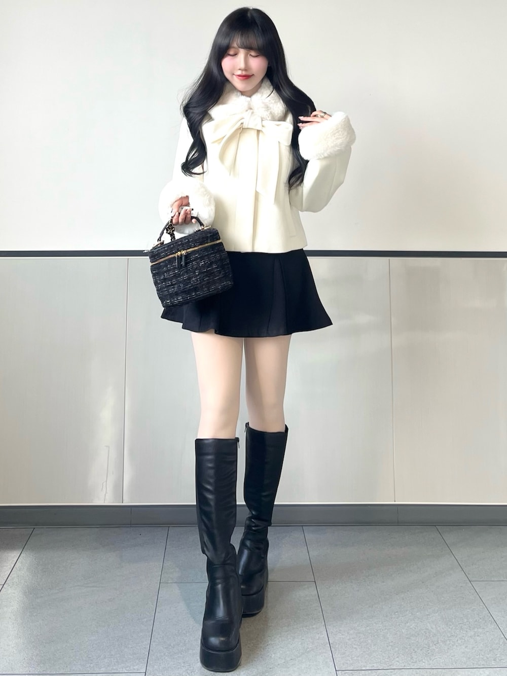 ホワイト系のダウンジャケット/コート、ブラック系のスカート、ブラック系のショルダーバッグを着用したレディースの冬コーディネートの2枚目の写真