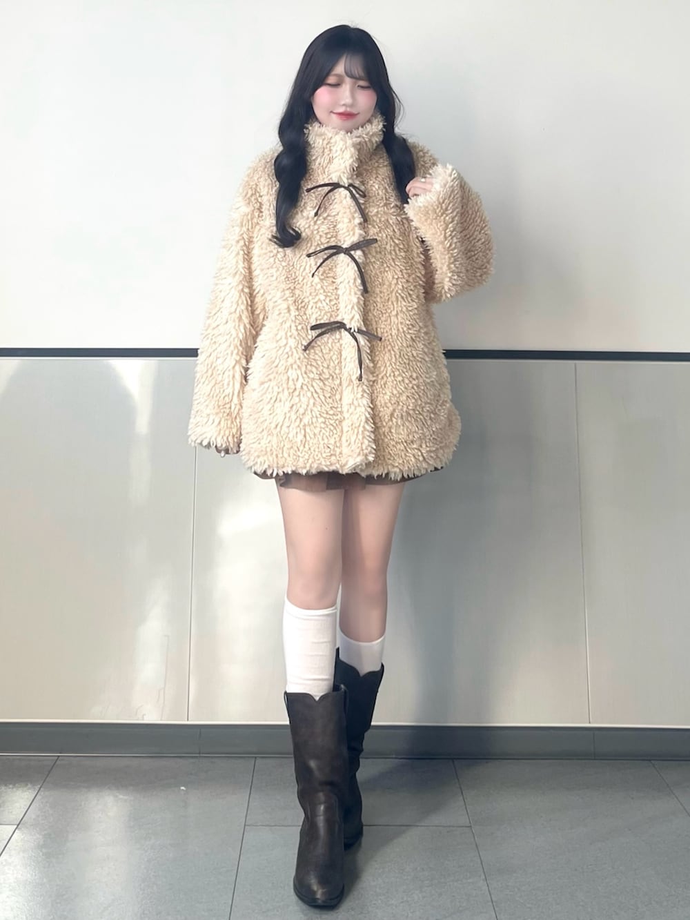 ベージュ系のブルゾン、イエロー系のハンドバッグ、イエロー系のスカートを着用したレディースの秋コーディネートの4枚目の写真