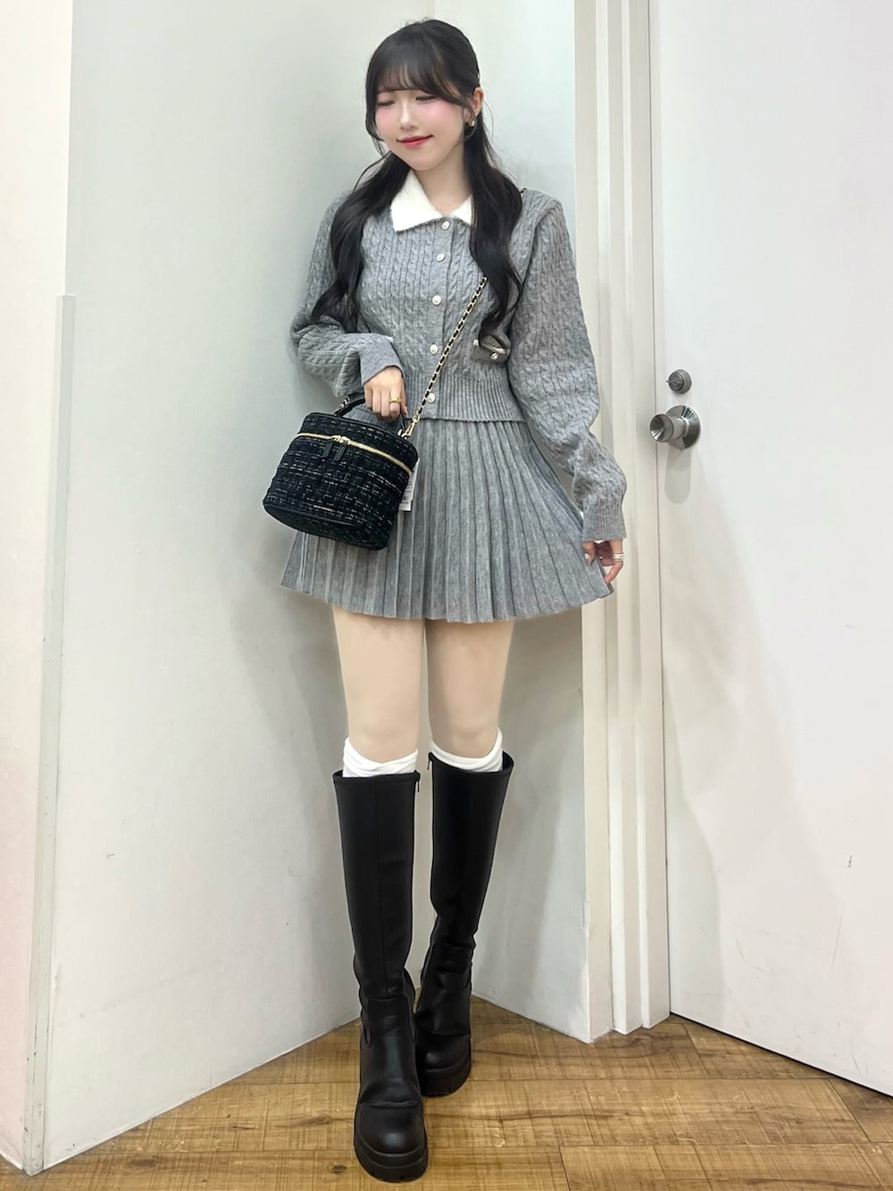 グレー系のカーディガン/ボレロ、ブラック系のショルダーバッグ、ブラック系のブーツを着用したレディースの冬コーディネートの2枚目の写真