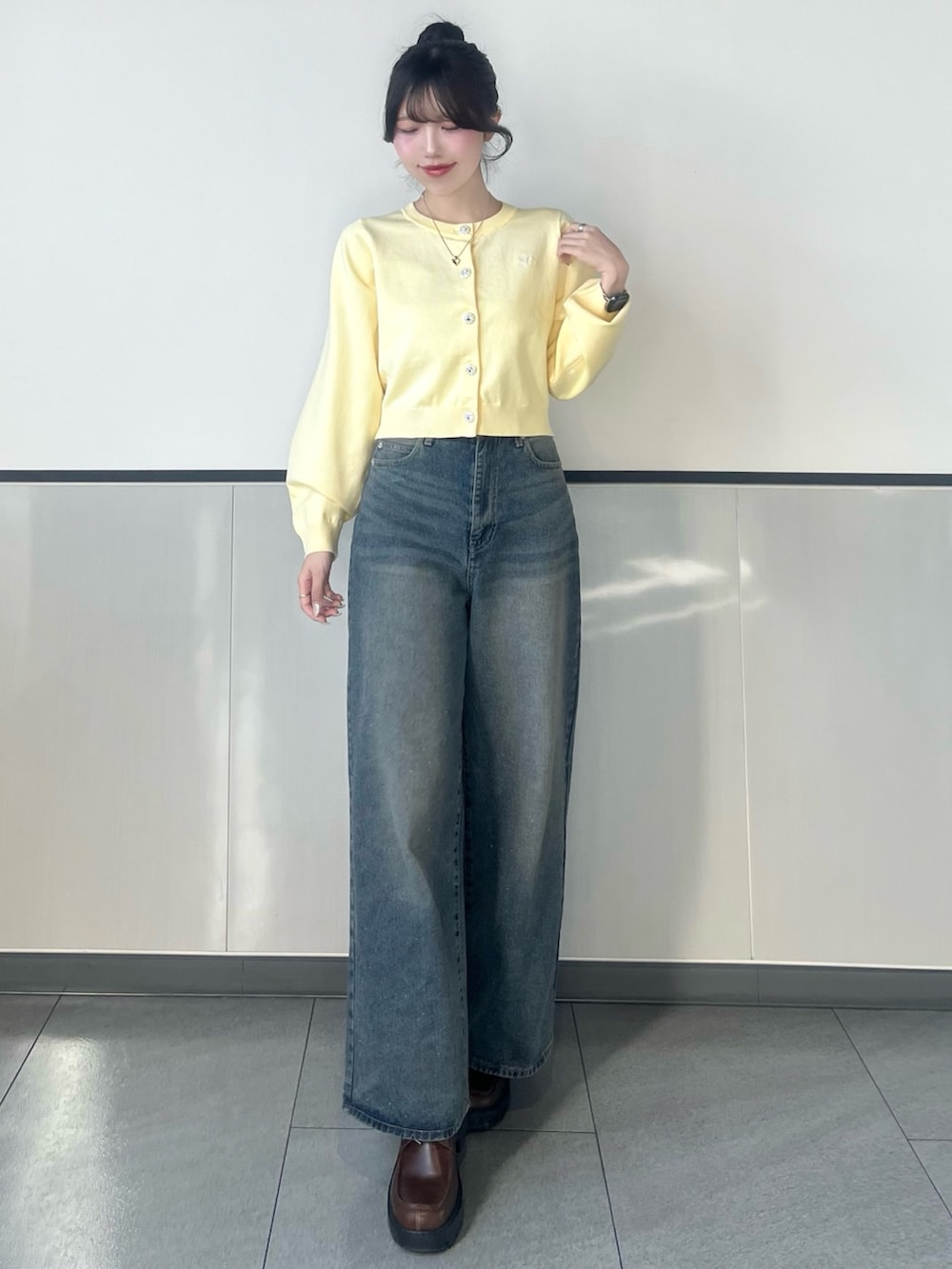 イエロー系のカーディガン/ボレロ、ブルー系のデニムパンツを着用したレディースの冬コーディネートの2枚目の写真
