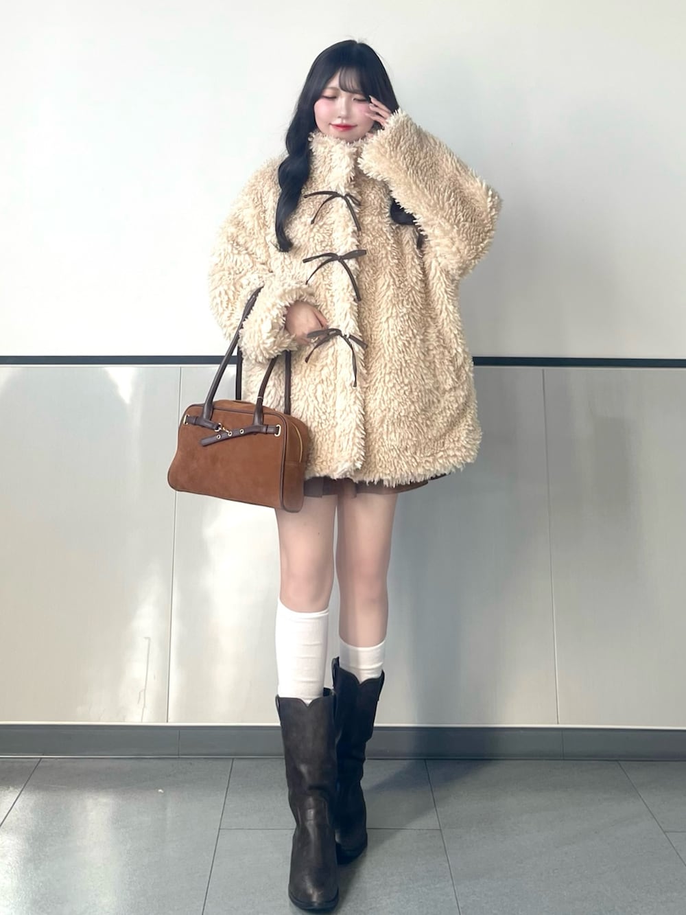 ベージュ系のブルゾン、イエロー系のハンドバッグ、イエロー系のスカートを着用したレディースの秋コーディネートの2枚目の写真