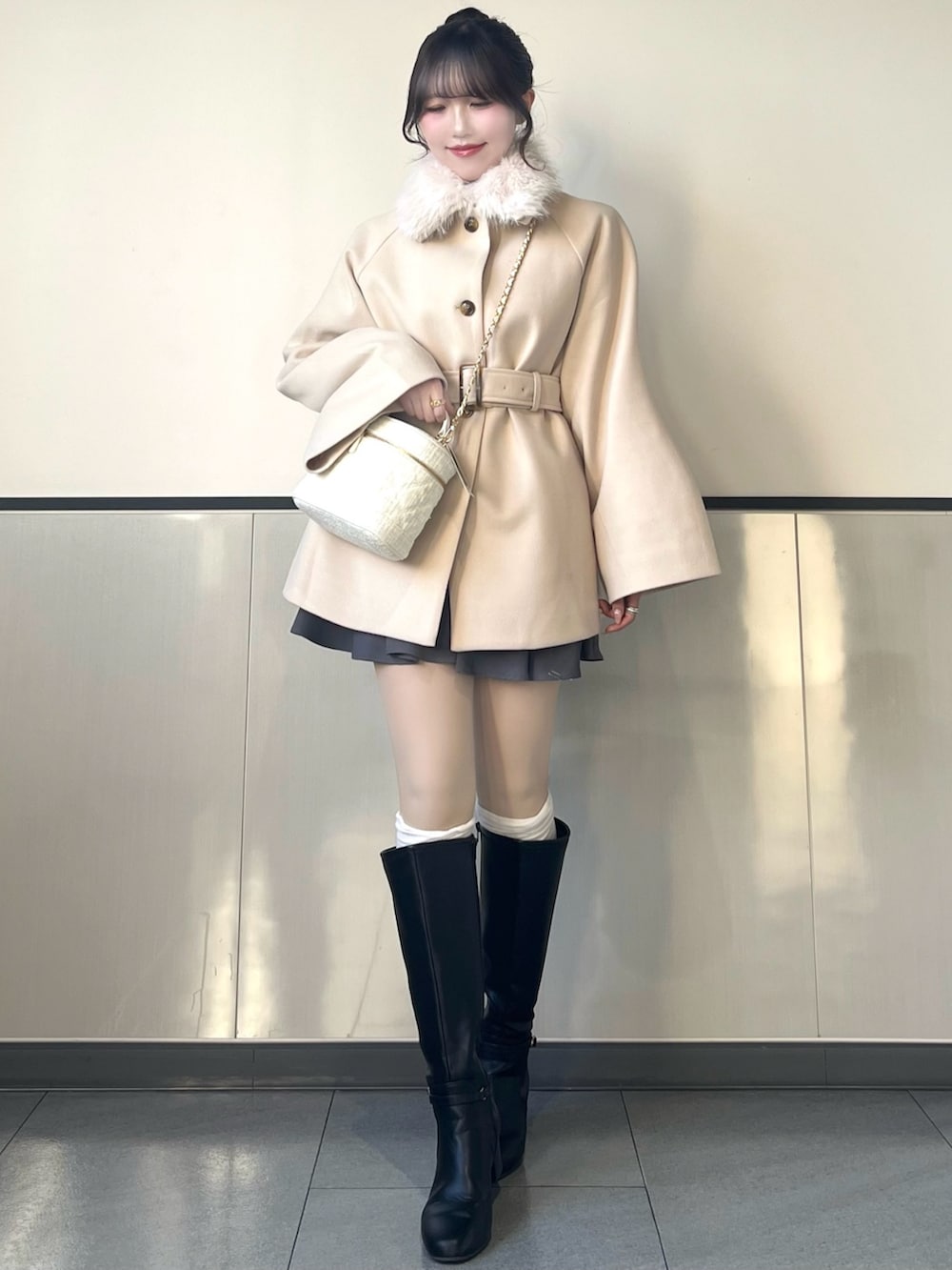 ホワイト系のその他アウター、ホワイト系のショルダーバッグ、グレー系のスカートを着用したレディースの秋コーディネートの3枚目の写真