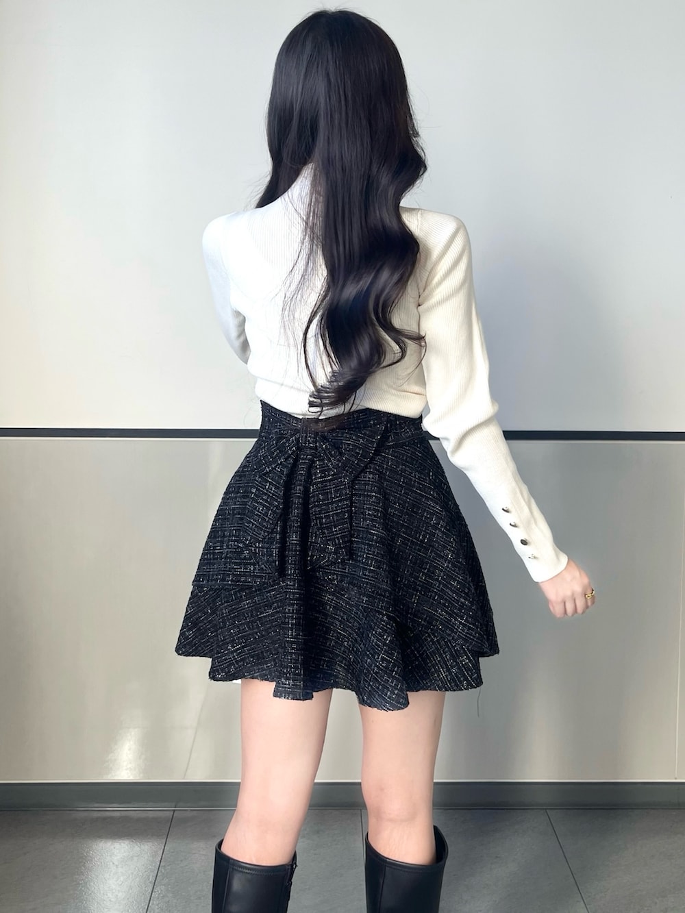 グレー系のブルゾン、ブラック系のスカート、ブラック系のショルダーバッグを着用したレディースの秋コーディネートの2枚目の写真