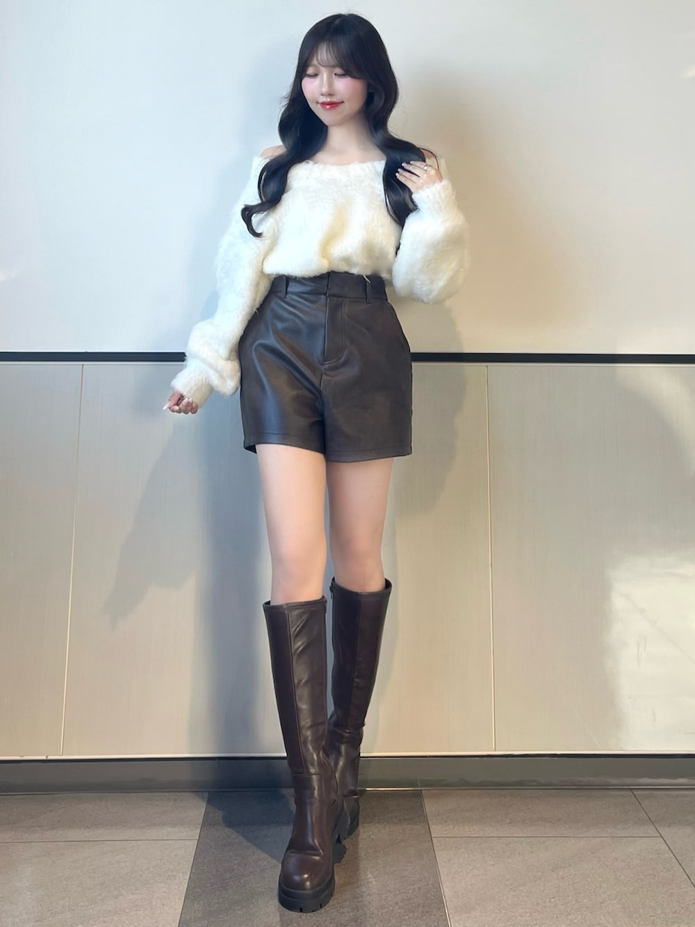 ホワイト系のニット/セーター、ブラウン系のその他パンツ、ブラウン系のブーツを着用したレディースの秋コーディネートの2枚目の写真