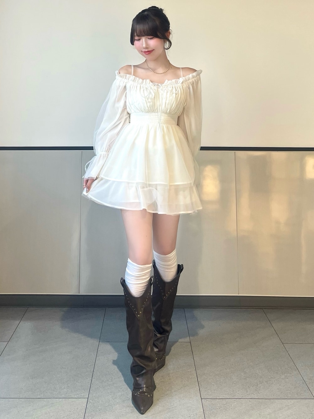 ホワイト系のワンピース、ブラウン系のボストンバッグを着用したレディースの春コーディネートの2枚目の写真