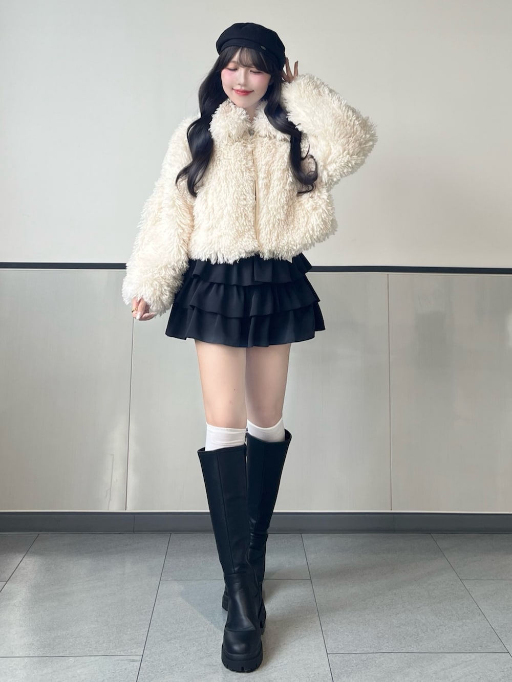 ホワイト系のブルゾン、ブラック系のスカート、ブラック系のブーツを着用したレディースの秋コーディネートの3枚目の写真