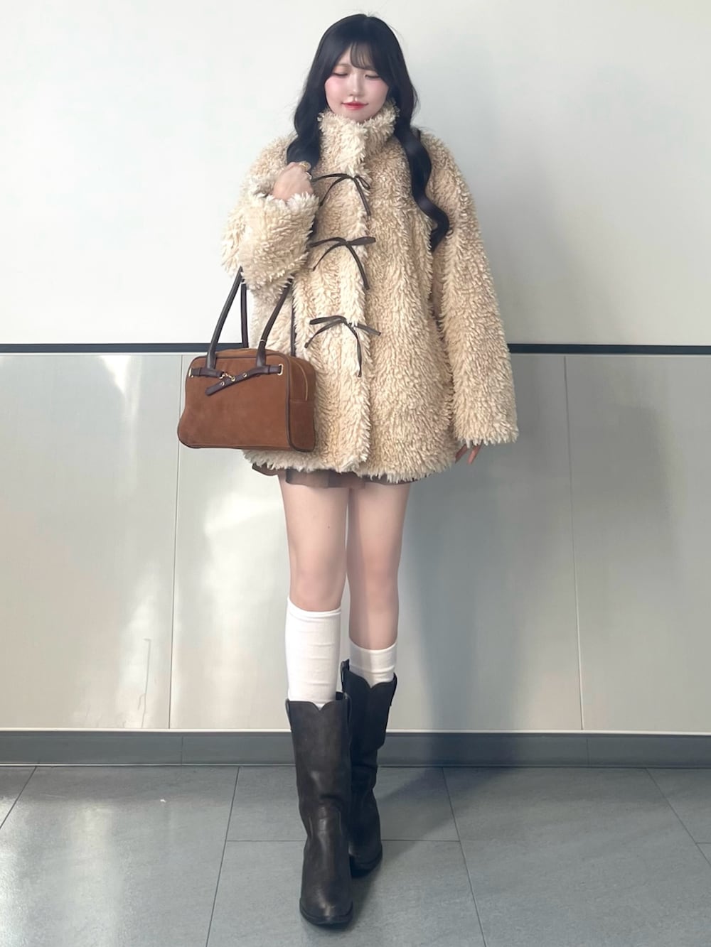 ベージュ系のブルゾン、イエロー系のハンドバッグ、イエロー系のスカートを着用したレディースの秋コーディネートの3枚目の写真