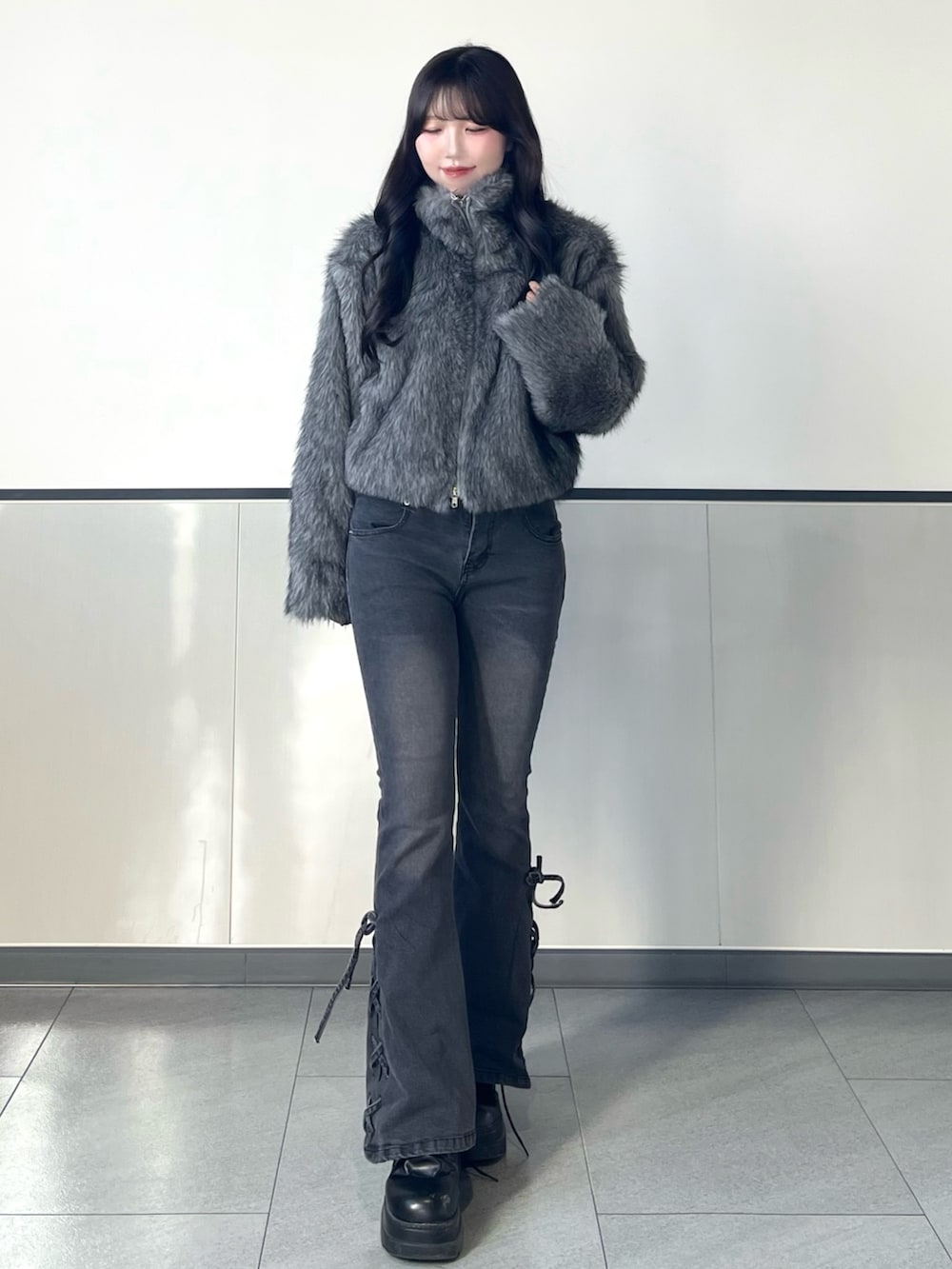 グレー系のブルゾン、グレー系のデニムパンツを着用したレディースの秋コーディネートの3枚目の写真