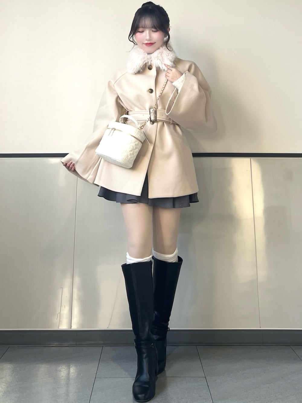 ホワイト系のその他アウター、ホワイト系のショルダーバッグ、グレー系のスカートを着用したレディースの秋コーディネートの2枚目の写真