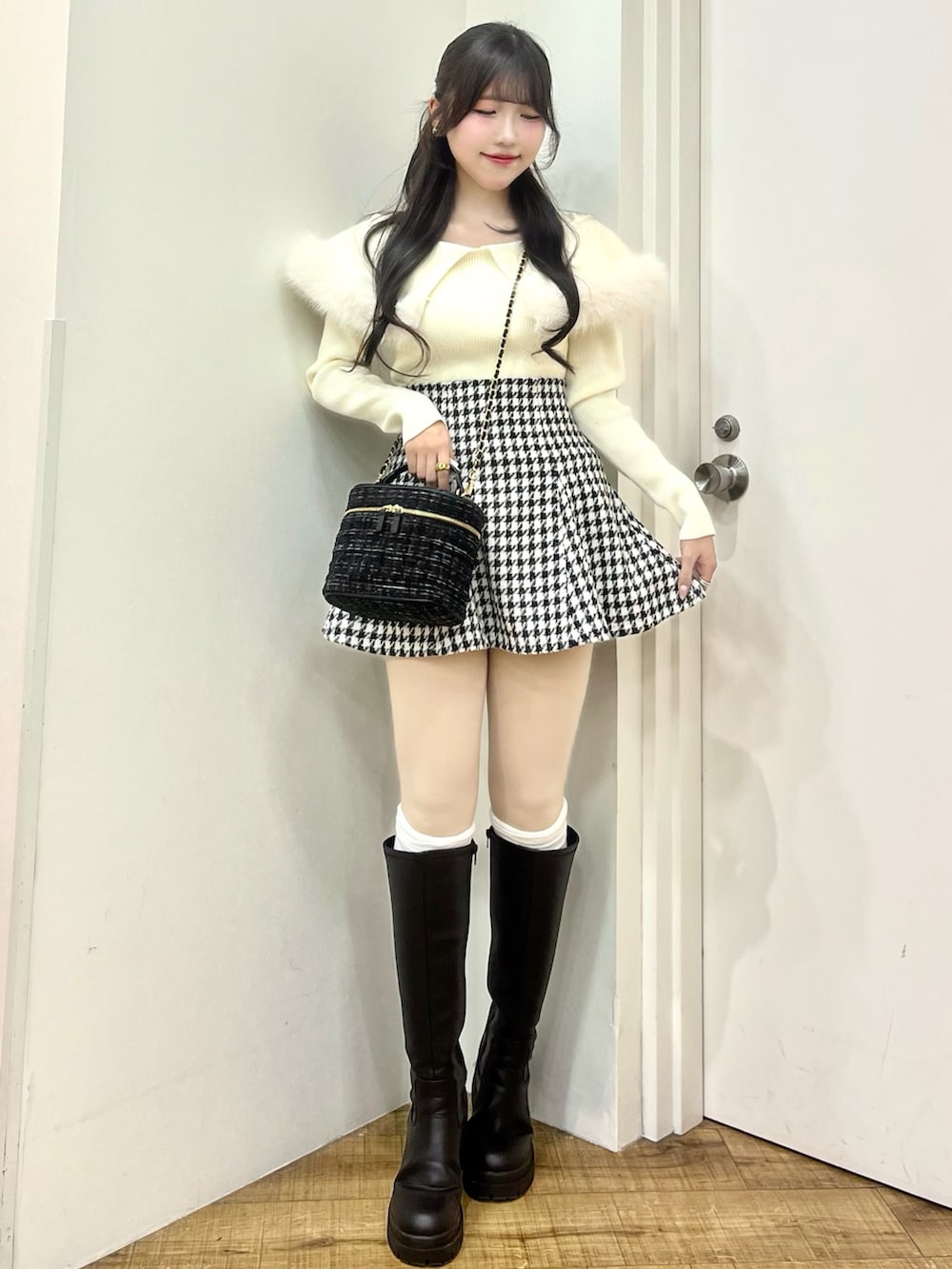 ホワイト系のニット/セーター、その他のスカート、ブラック系のショルダーバッグを着用したレディースの冬コーディネートの2枚目の写真