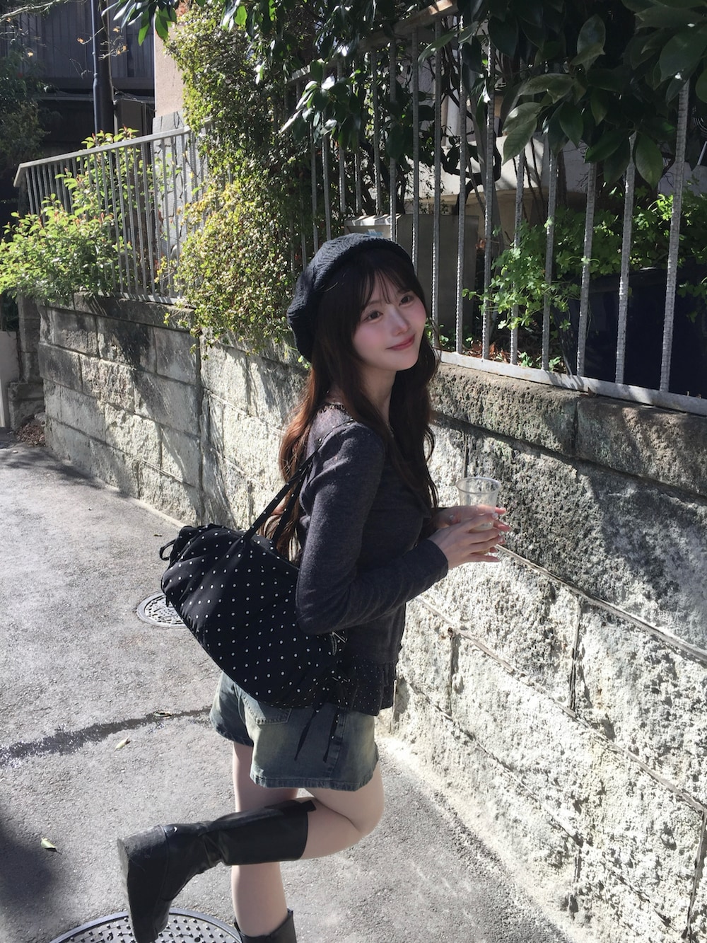 グレー系のトップス、ブルー系のパンツ、ブラック系のショルダーバッグを着用したレディースの春コーディネートの2枚目の写真