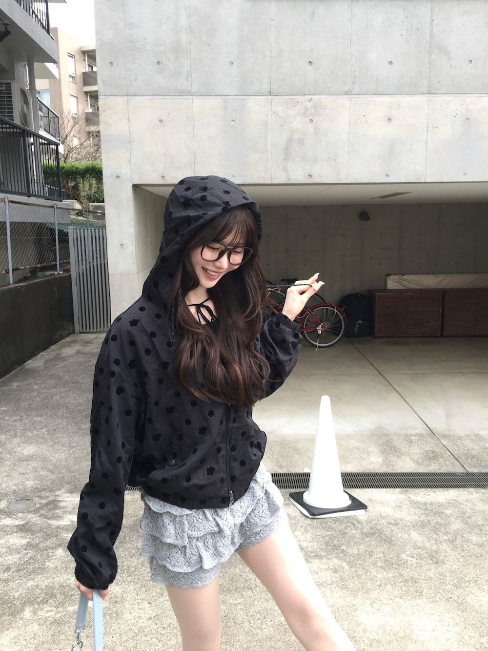 グレー系のスカート、ブラック系のナイロンジャケット、ブルー系のバッグを着用したレディースの春コーディネートの3枚目の写真