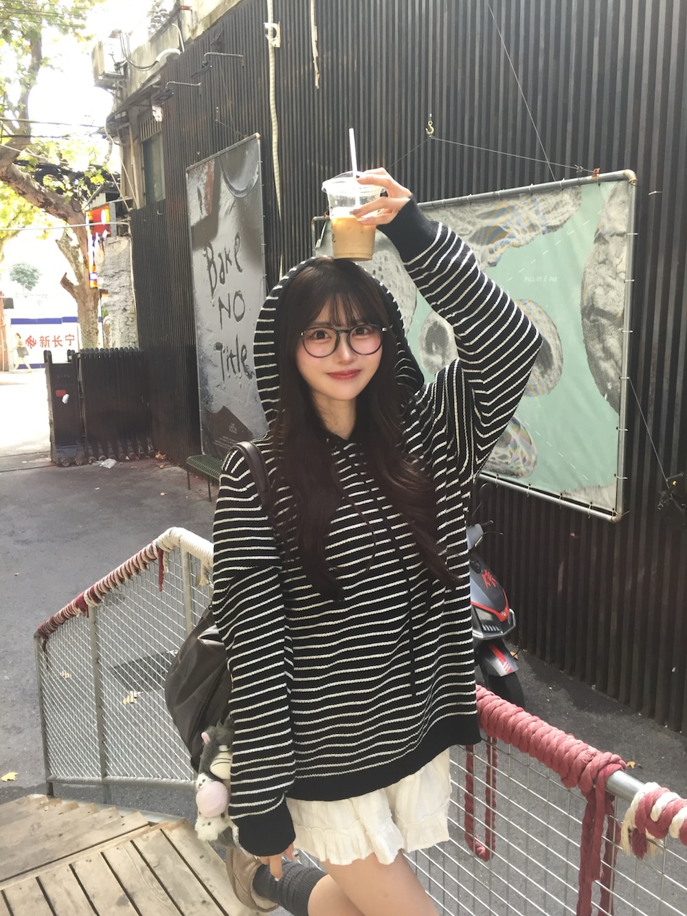 ブラック系のニット/セーター、ホワイト系のスカート、ブラウン系のショルダーバッグを着用したレディースの秋コーディネートの2枚目の写真