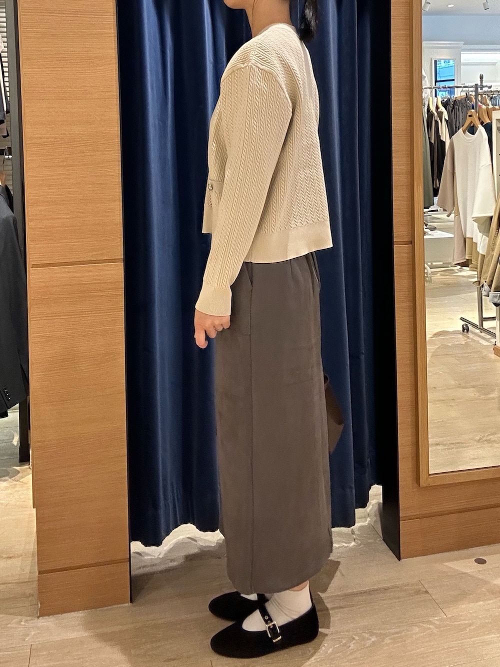 ホワイト系のニット/セーター、グレー系のスカート、ブラウン系のトートバッグを着用したレディースの秋コーディネートの4枚目の写真