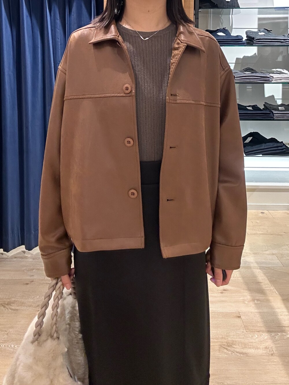 ブラウン系のニット/セーター、イエロー系のブルゾン、ホワイト系のトートバッグを着用したレディースの秋コーディネートの5枚目の写真