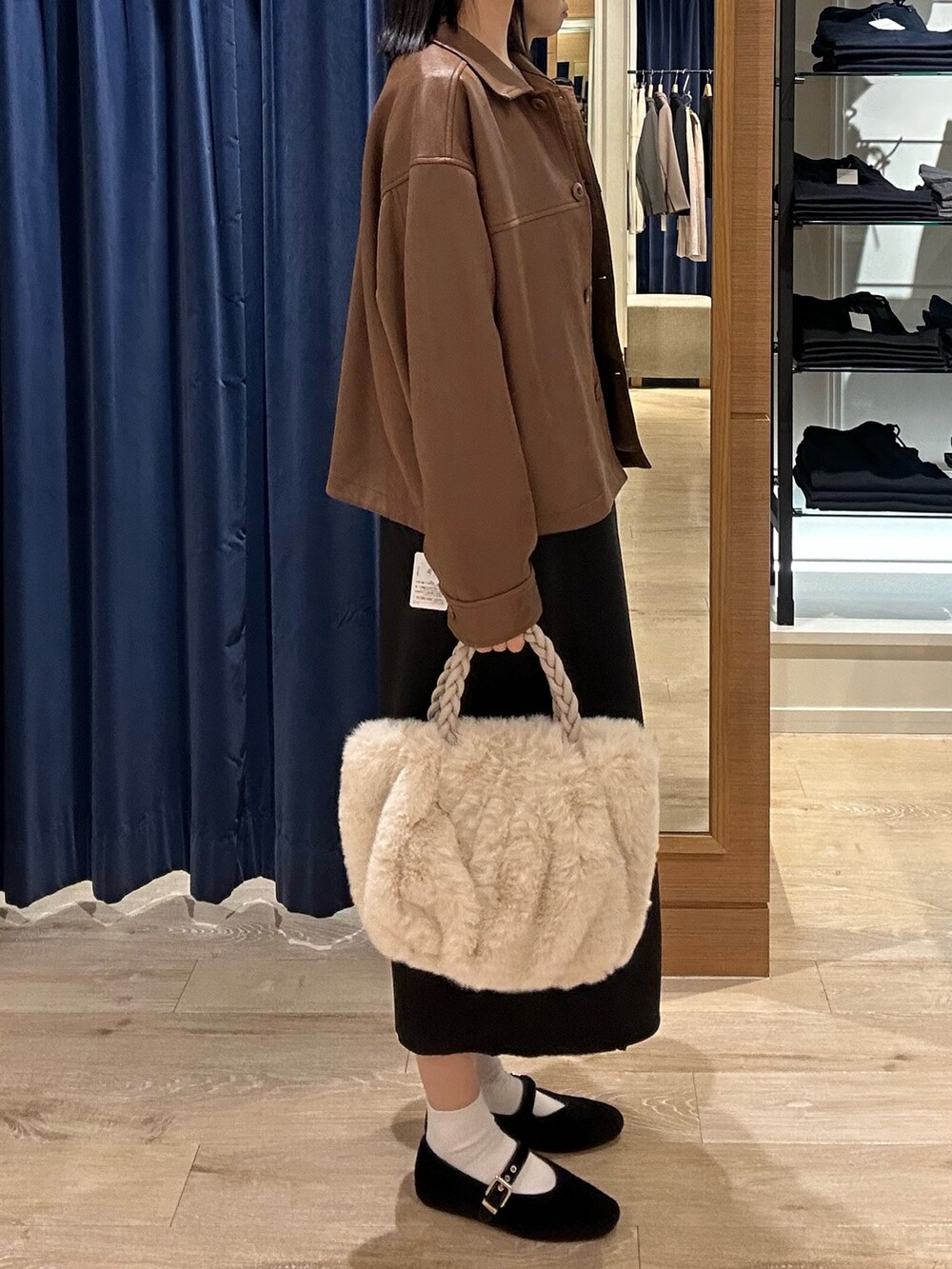 ブラウン系のニット/セーター、イエロー系のブルゾン、ホワイト系のトートバッグを着用したレディースの秋コーディネートの2枚目の写真