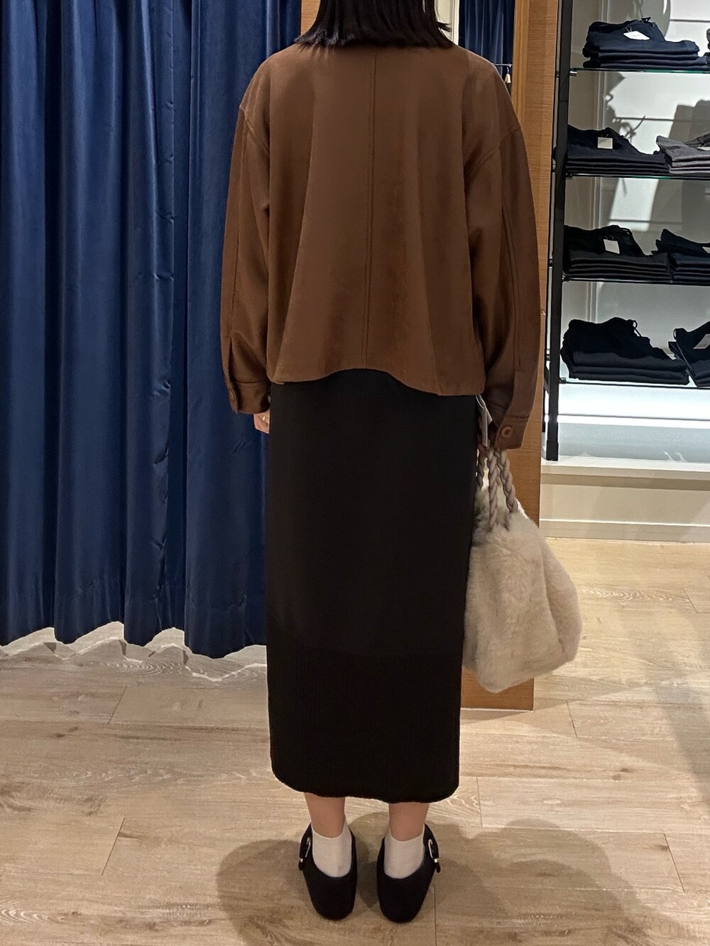 ブラウン系のニット/セーター、イエロー系のブルゾン、ホワイト系のトートバッグを着用したレディースの秋コーディネートの3枚目の写真