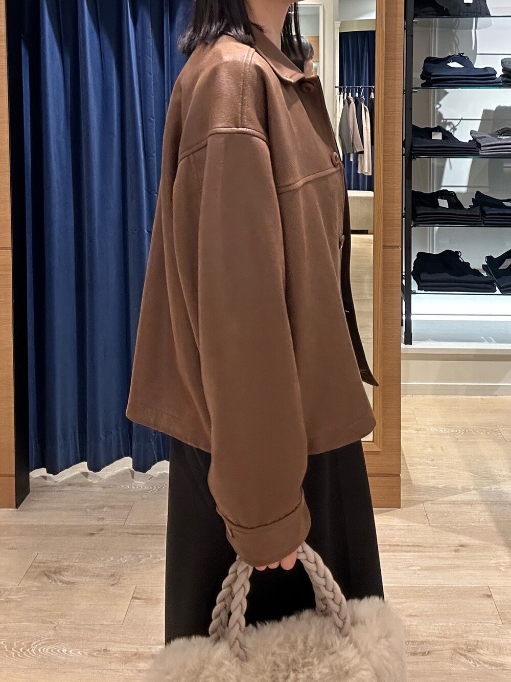 ブラウン系のニット/セーター、イエロー系のブルゾン、ホワイト系のトートバッグを着用したレディースの秋コーディネートの6枚目の写真