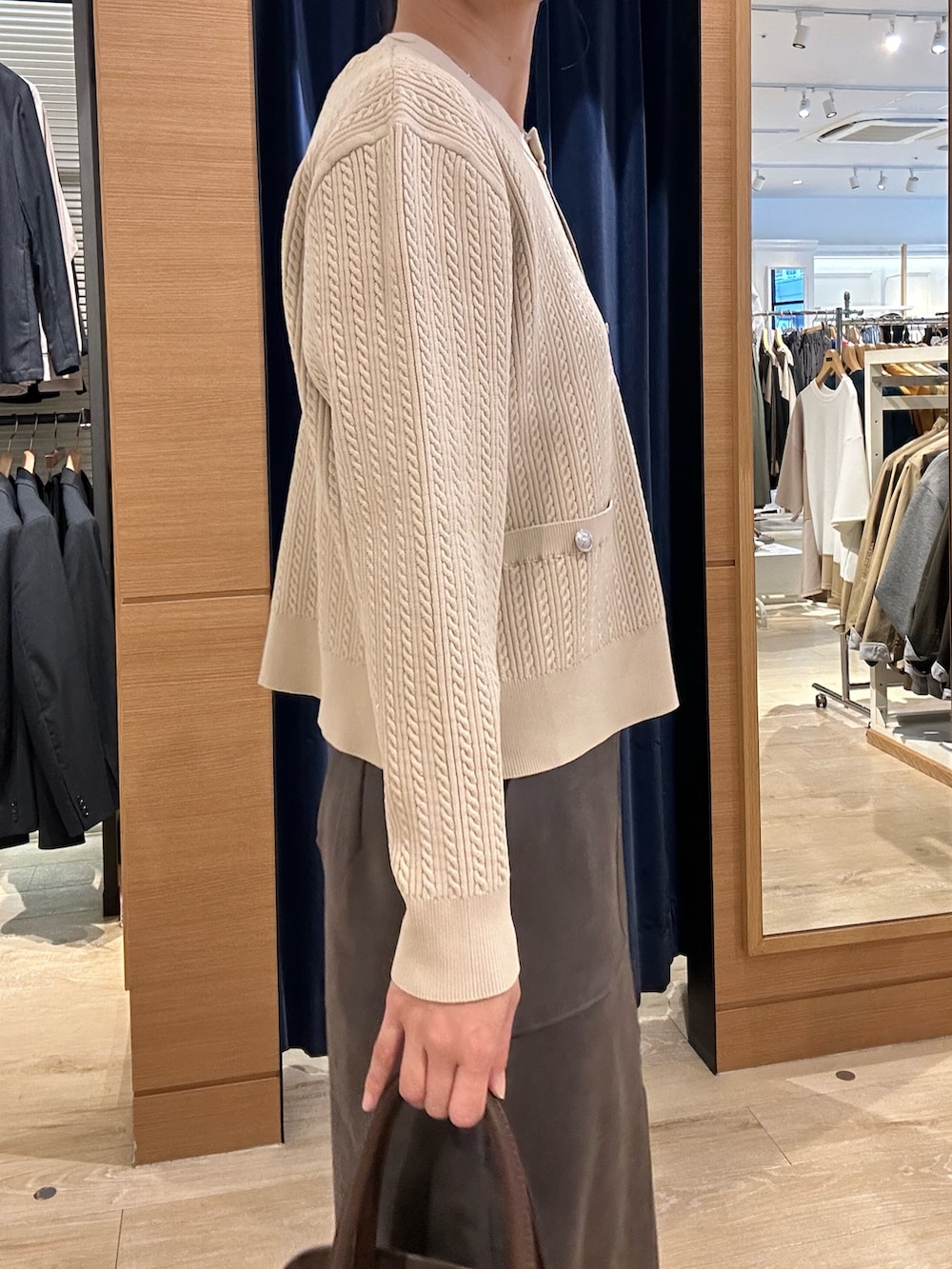 ホワイト系のニット/セーター、グレー系のスカート、ブラウン系のトートバッグを着用したレディースの秋コーディネートの6枚目の写真
