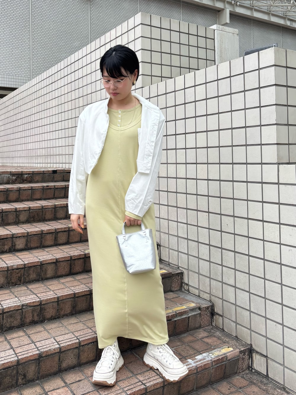 ホワイト系のブルゾン、グリーン系のワンピース、シルバー系のトートバッグを着用したレディースの春コーディネートの4枚目の写真