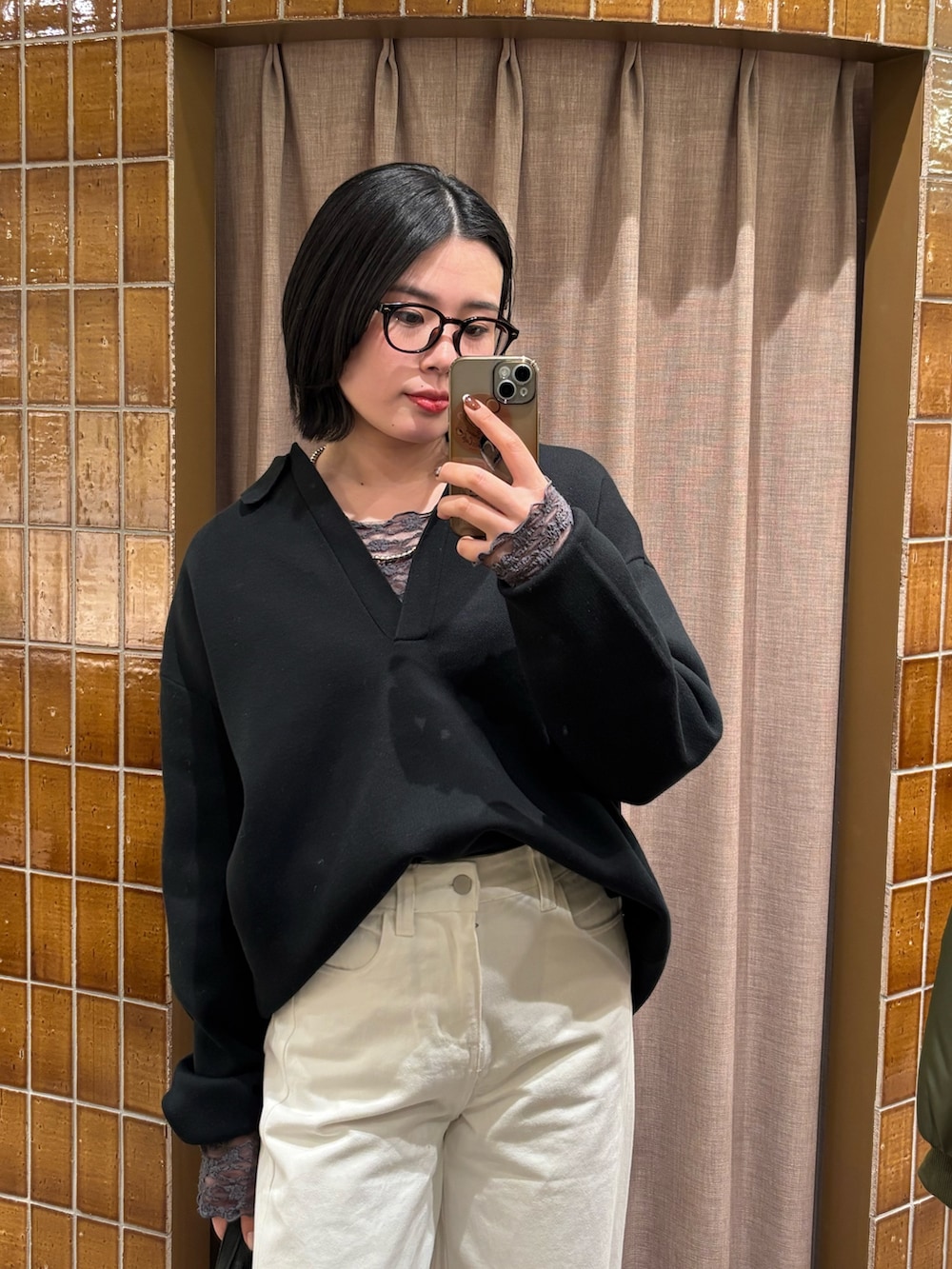 ブラック系のニット/セーター、ホワイト系のデニムパンツ、ブラック系のトートバッグを着用したレディースの冬コーディネートの2枚目の写真