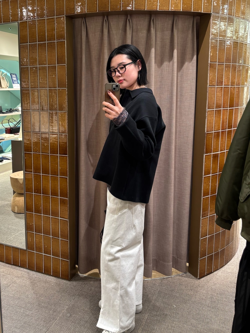 ブラック系のニット/セーター、ホワイト系のデニムパンツ、ブラック系のトートバッグを着用したレディースの冬コーディネートの3枚目の写真