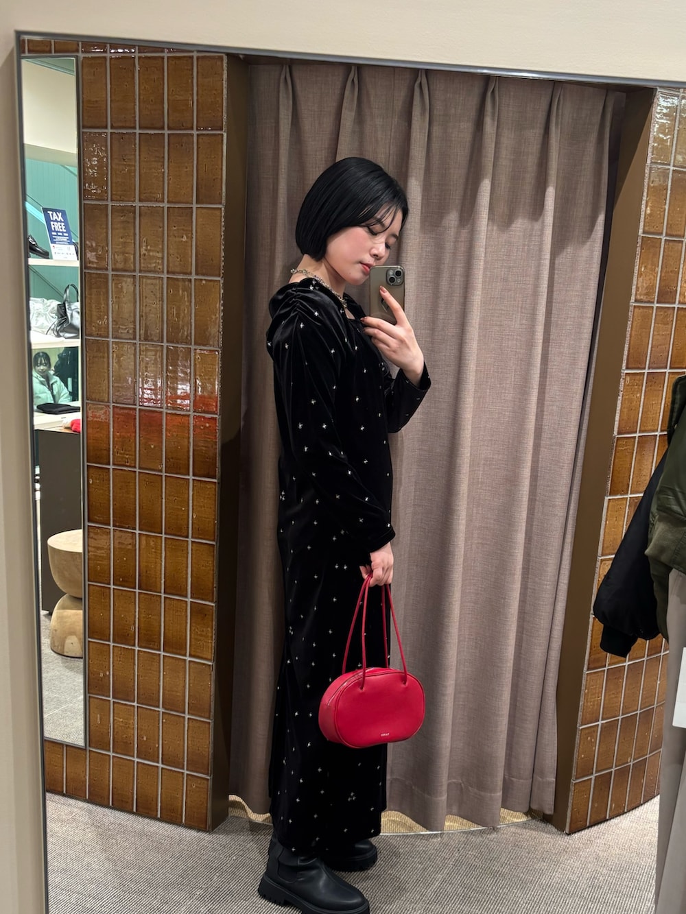 ブラック系のワンピース、ブラック系のブーツを着用したレディースの冬コーディネートの3枚目の写真