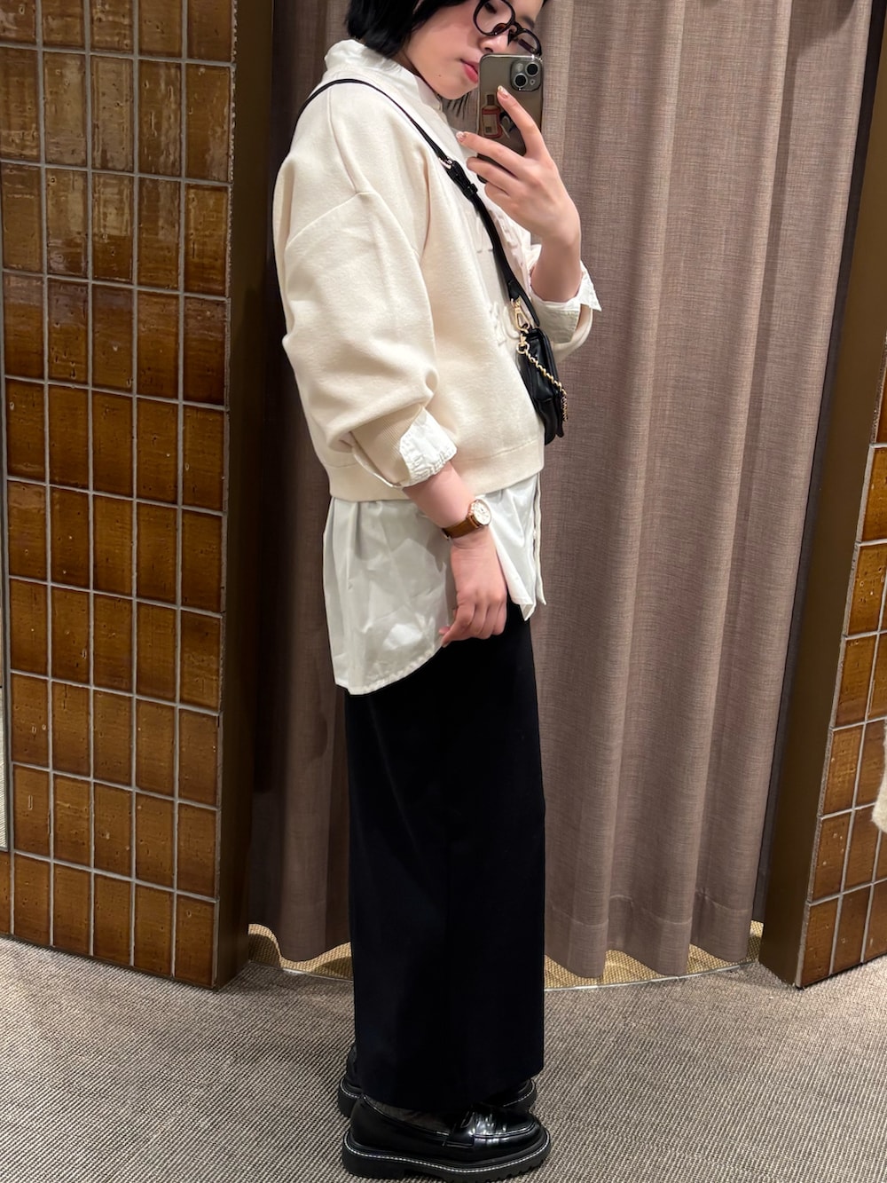 ホワイト系のニット/セーター、ホワイト系のシャツ/ブラウス、ブラック系のスカートを着用したレディースの冬コーディネートの3枚目の写真