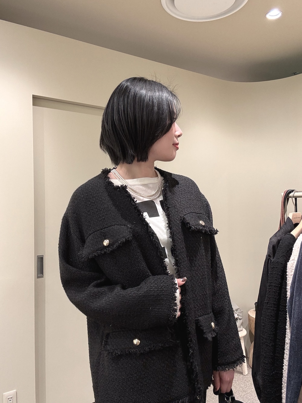 ブラック系のその他アウター、ホワイト系のTシャツ/カットソー、ブラック系のスカートを着用したレディースの冬コーディネートの2枚目の写真