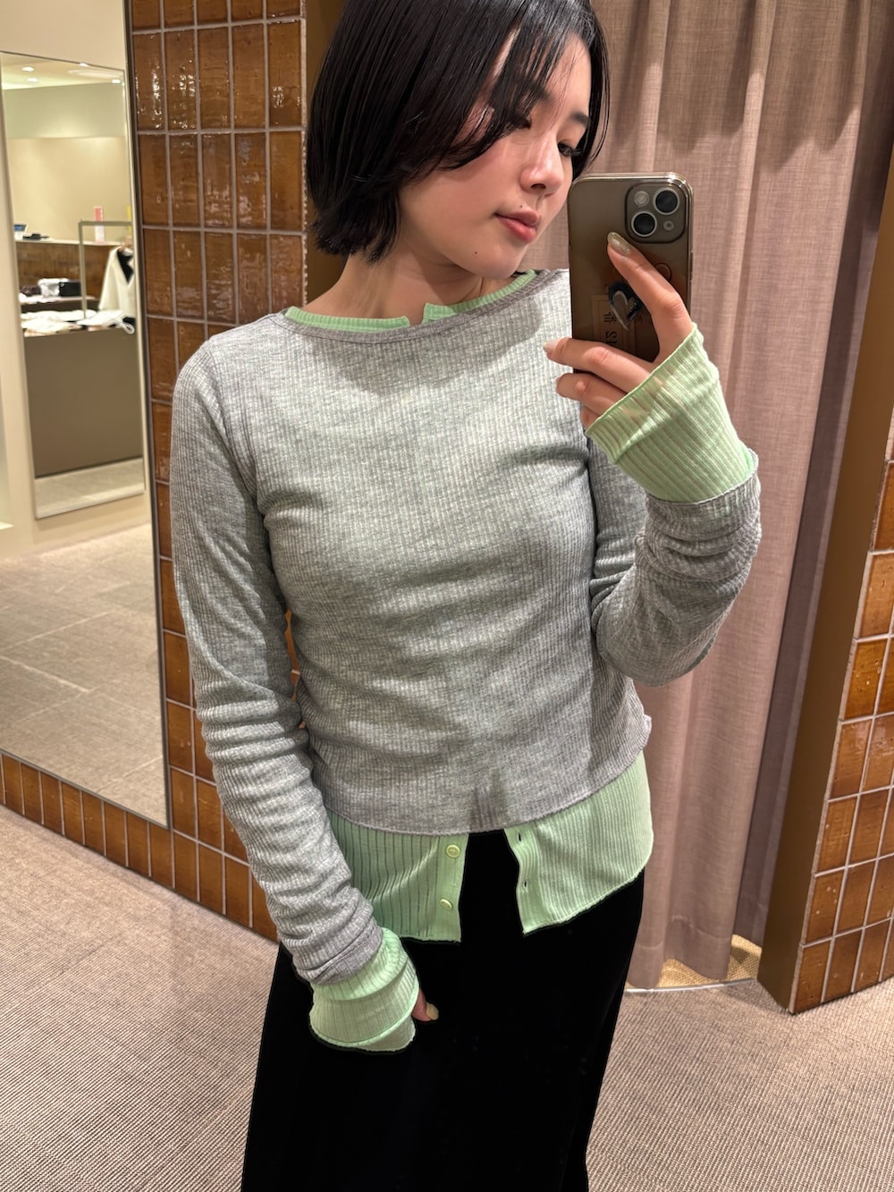 グリーン系のTシャツ/カットソー、ブラック系のスカートを着用したレディースの春コーディネートの2枚目の写真