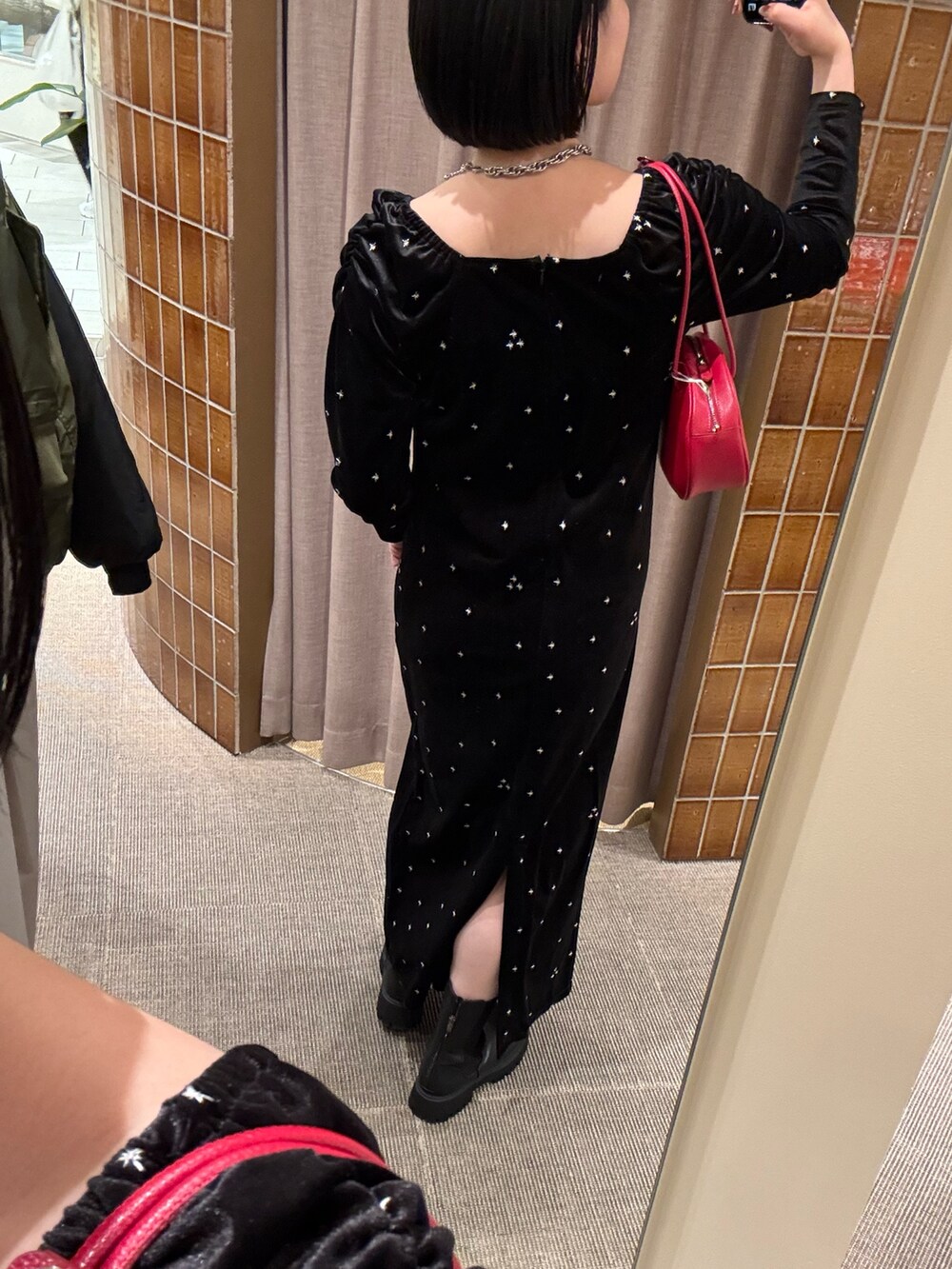 ブラック系のワンピース、ブラック系のブーツを着用したレディースの冬コーディネートの4枚目の写真