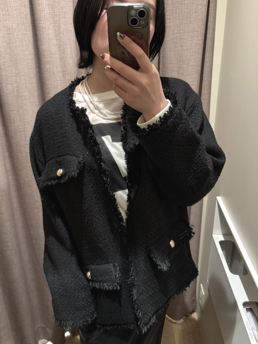 ブラック系のその他アウター、ホワイト系のTシャツ/カットソー、ブラック系のスカートを着用したレディースの冬コーディネートの3枚目の写真