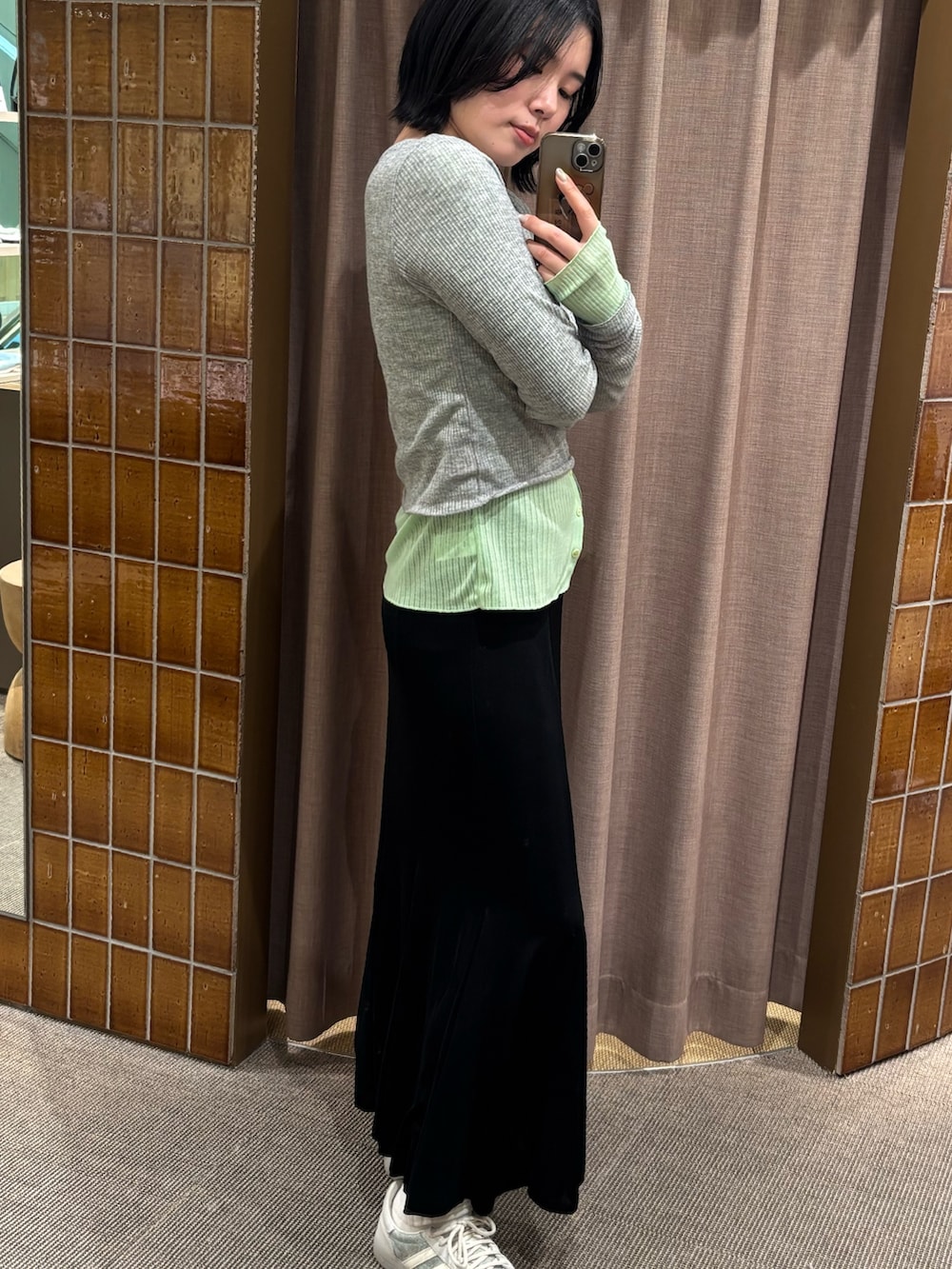 グリーン系のTシャツ/カットソー、ブラック系のスカートを着用したレディースの春コーディネートの3枚目の写真