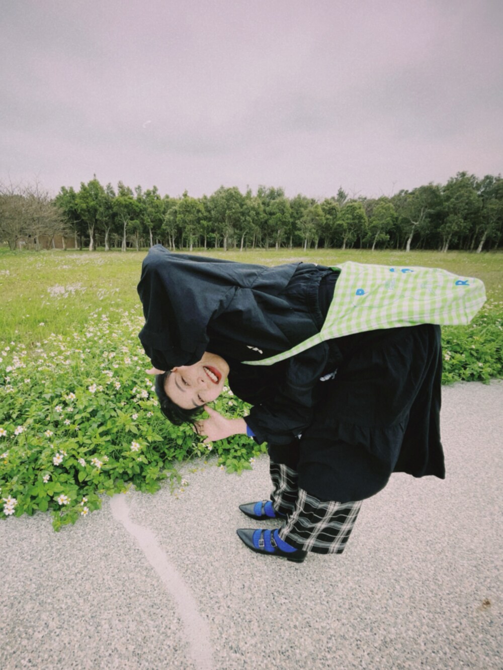 ブルー系のTシャツ/カットソー、ブラック系のワンピース、ブラック系のチノパンツを着用したレディースの春コーディネートの2枚目の写真