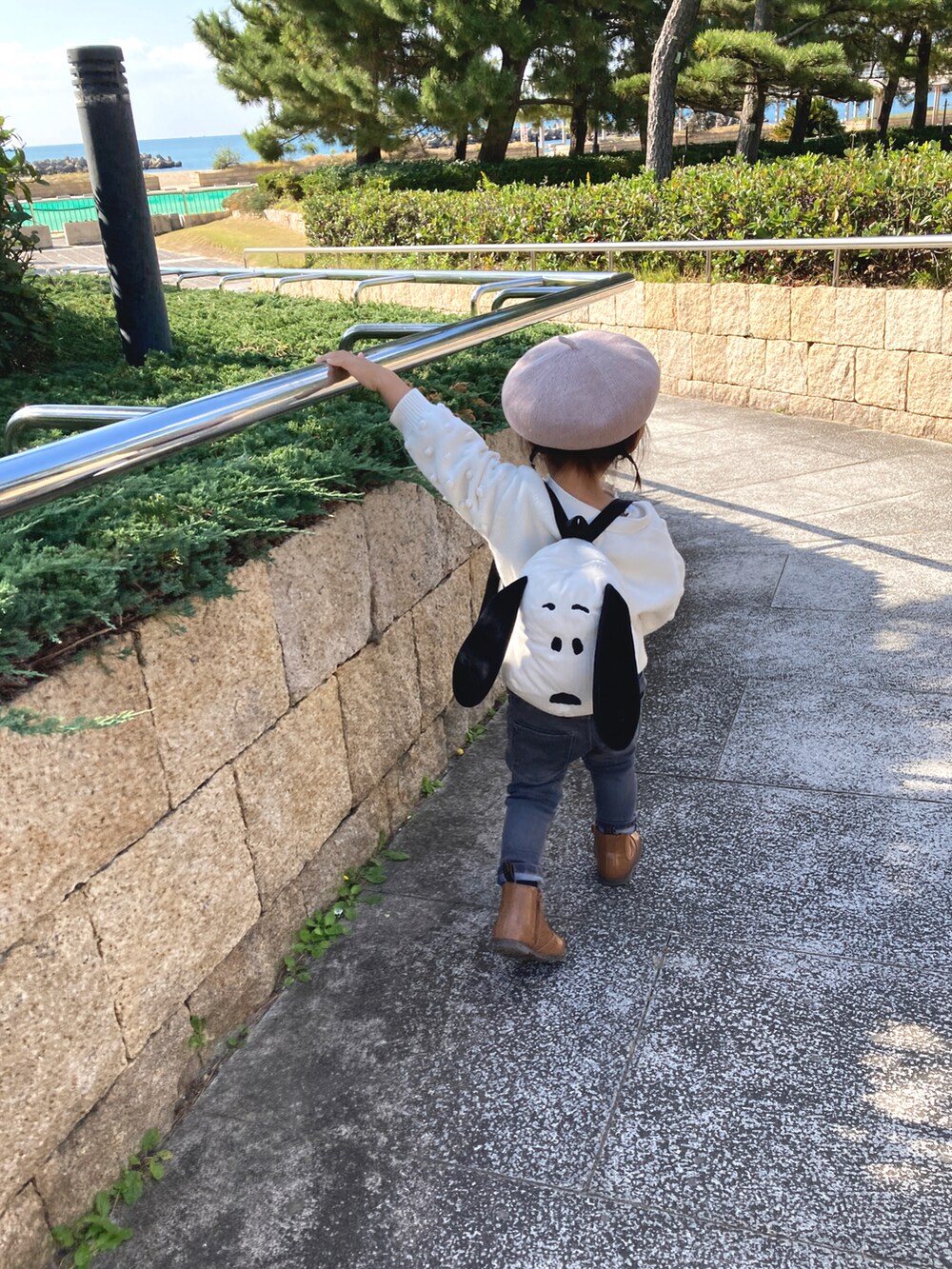 ホワイト系のカーディガン/ボレロ、グレー系のデニムパンツ、ブラウン系のブーツを着用したキッズの秋コーディネートの2枚目の写真