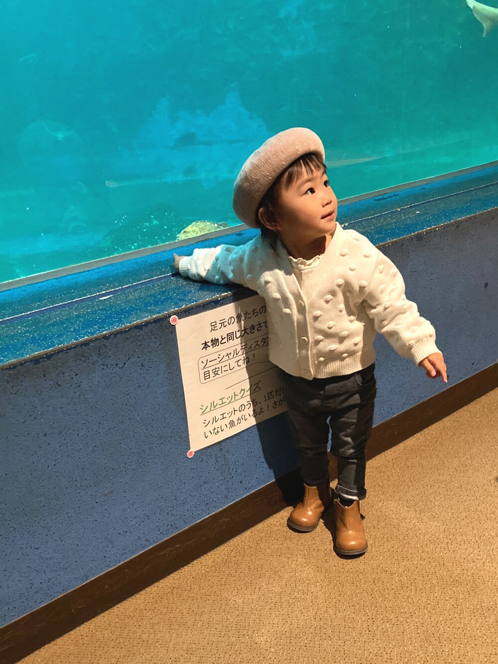 ホワイト系のカーディガン/ボレロ、グレー系のデニムパンツ、ブラウン系のブーツを着用したキッズの秋コーディネートの3枚目の写真