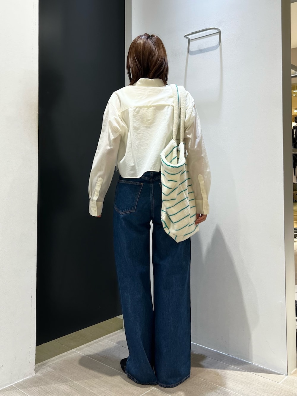 ホワイト系のシャツ/ブラウス、ブルー系のデニムパンツ、その他のトートバッグを着用したレディースの夏コーディネートの3枚目の写真