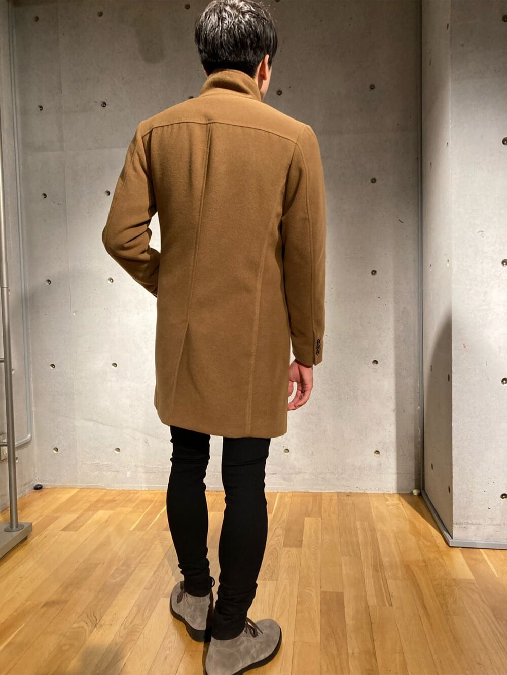 イエロー系のチェスターコート、グレー系のTシャツ/カットソー、ブラック系のカーゴパンツを着用したメンズの秋コーディネートの4枚目の写真