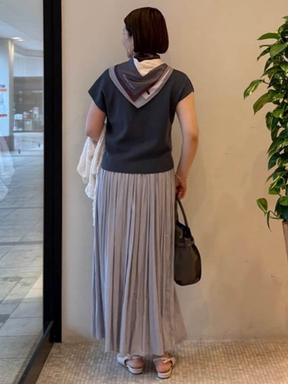 グレー系のショルダーバッグ、ホワイト系のブルゾン、ブルー系のワンピースを着用したレディースの春コーディネートの4枚目の写真