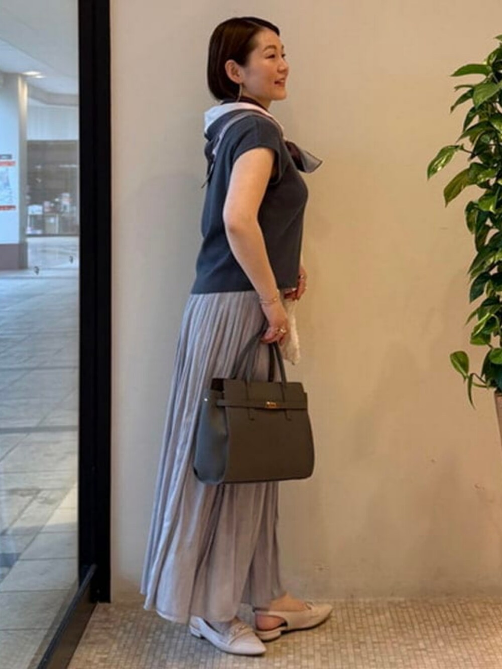 グレー系のショルダーバッグ、ホワイト系のブルゾン、ブルー系のワンピースを着用したレディースの春コーディネートの3枚目の写真