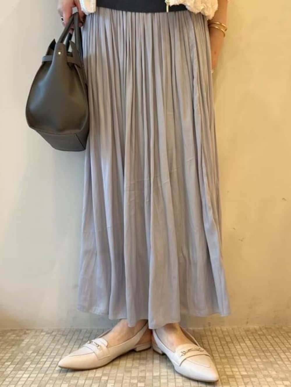 グレー系のショルダーバッグ、ホワイト系のブルゾン、ブルー系のワンピースを着用したレディースの春コーディネートの6枚目の写真