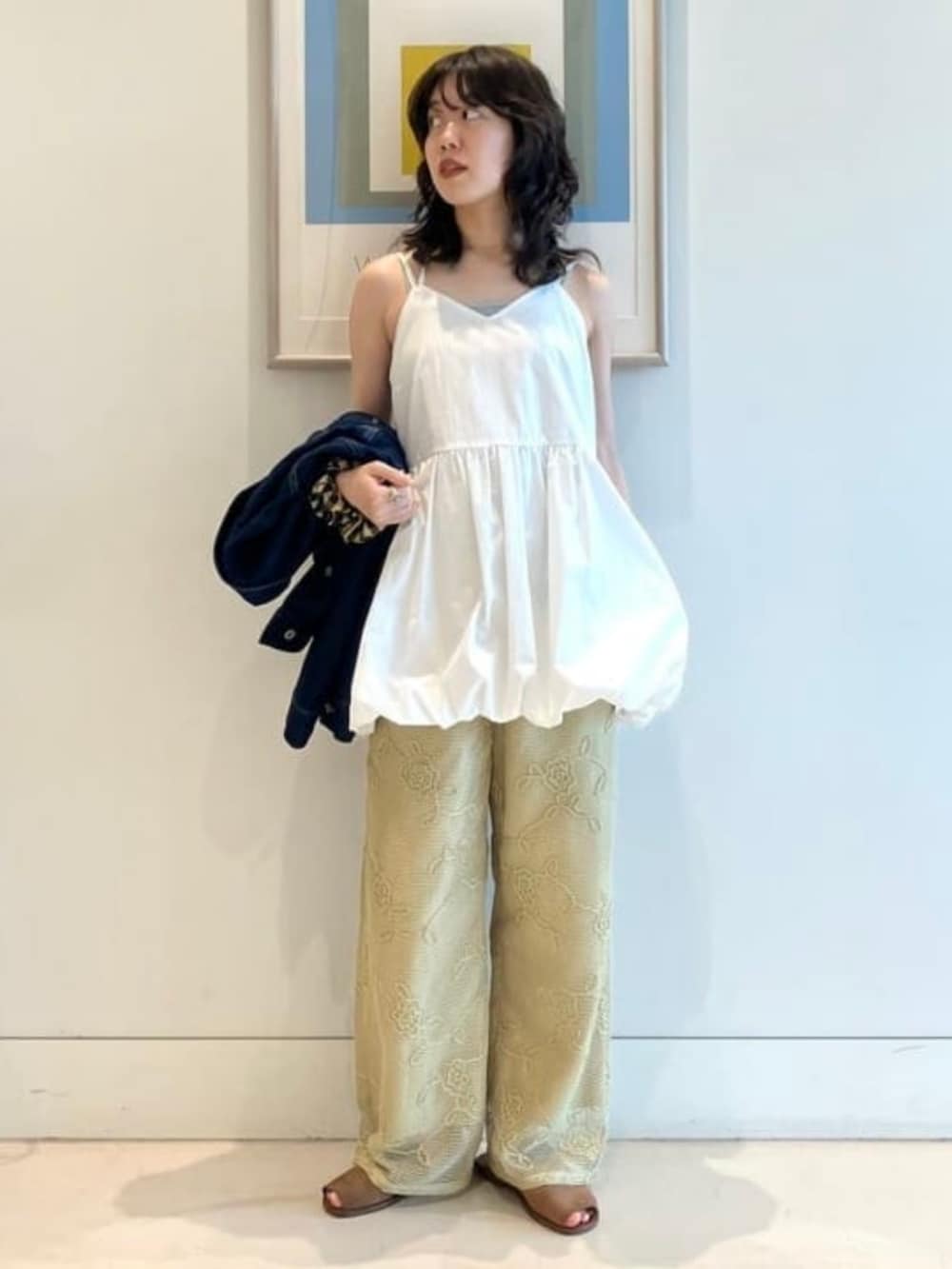 グリーン系のその他パンツ、ホワイト系のチュニックを着用したレディースの春コーディネートの3枚目の写真