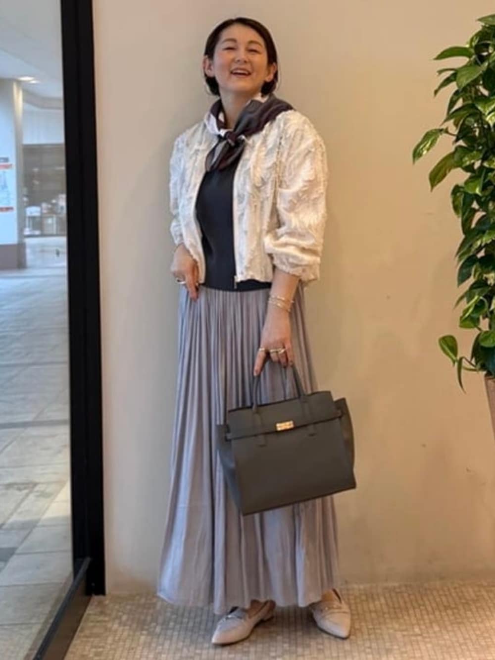 グレー系のショルダーバッグ、ホワイト系のブルゾン、ブルー系のワンピースを着用したレディースの春コーディネートの2枚目の写真