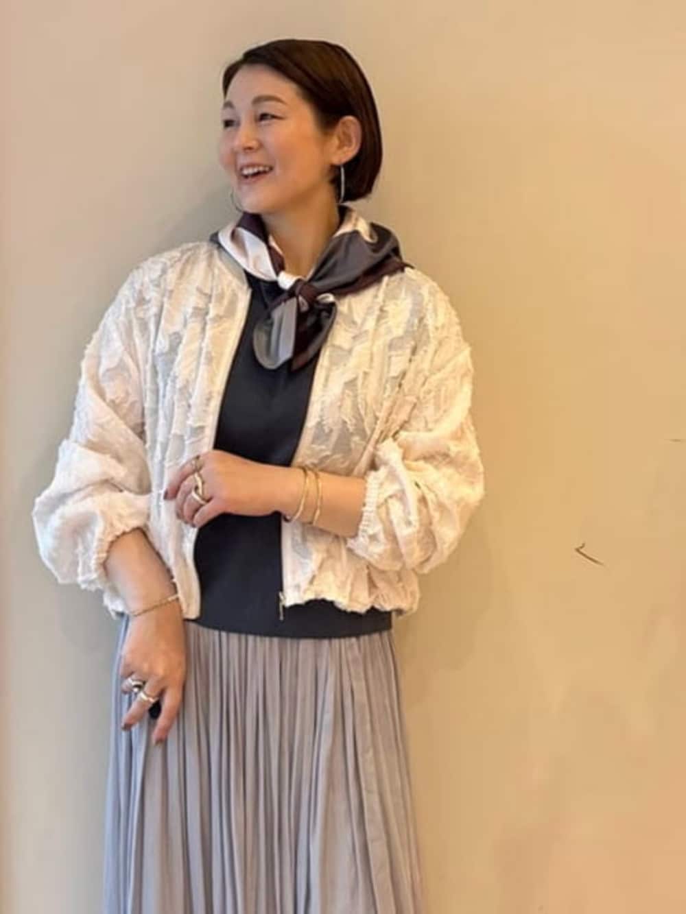 グレー系のショルダーバッグ、ホワイト系のブルゾン、ブルー系のワンピースを着用したレディースの春コーディネートの5枚目の写真