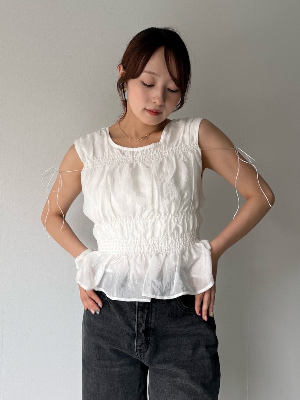 ブラック系のデニムパンツを着用したレディースの春コーディネートの3枚目の写真