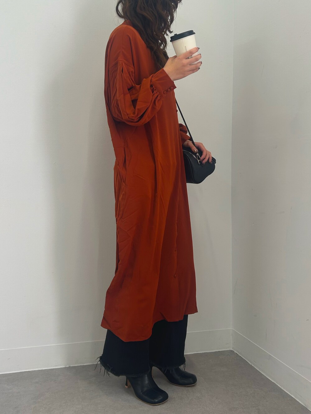オレンジ系のワンピースを着用したレディースの冬コーディネートの2枚目の写真